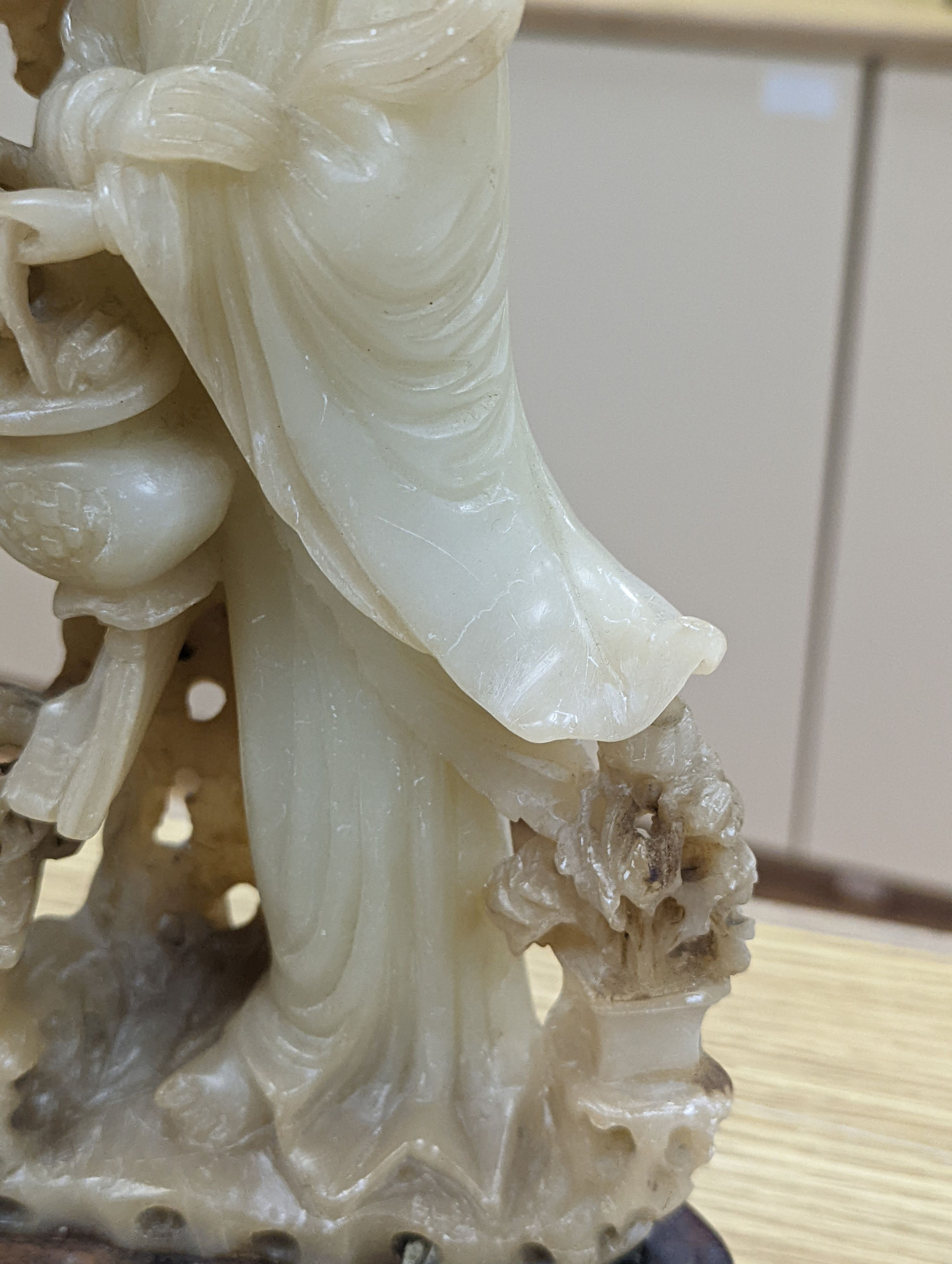 A Chinese soapstone carving of two ladies, wood stand, early 20th century, 36 cms high.